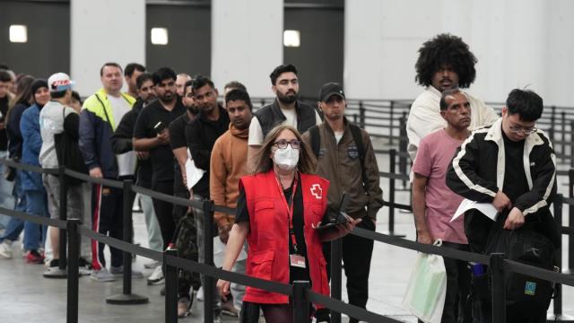 Decenas de migrantes hacen cola en el pabellón 2 del recinto de Montjuïc de Fira de Barcelona.
