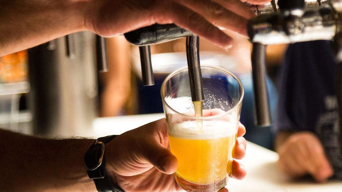 Camarero sirve una cerveza en un bar.