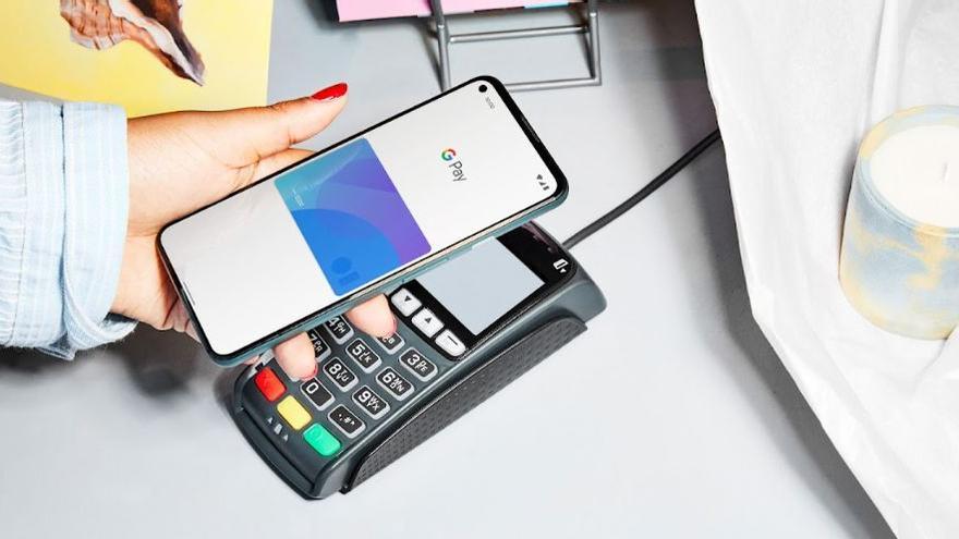 Persona pagando con el móvil y la aplicación de Google Pay.