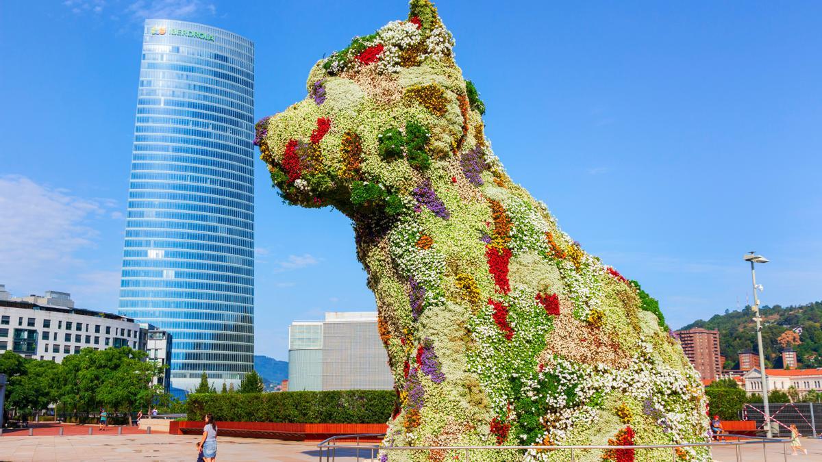 Pupi, el perro guardián del Guggenheim y la torre Iberdrola de fondo.