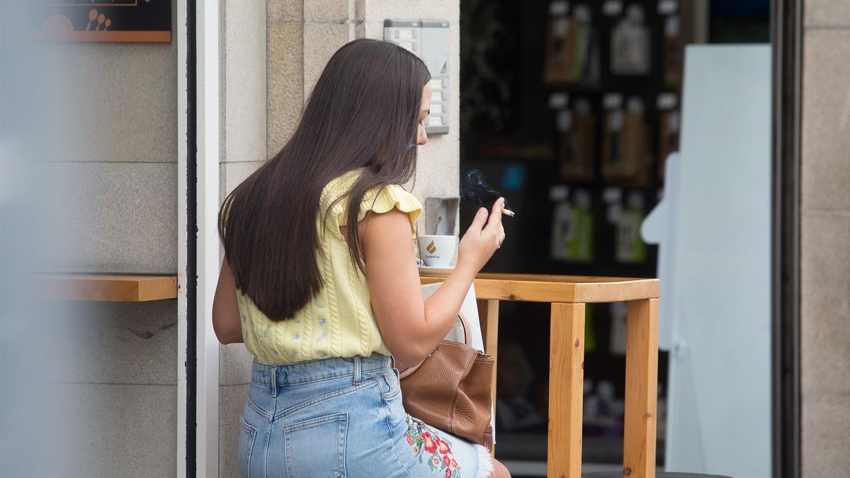 Una persona fuma en una terraza.