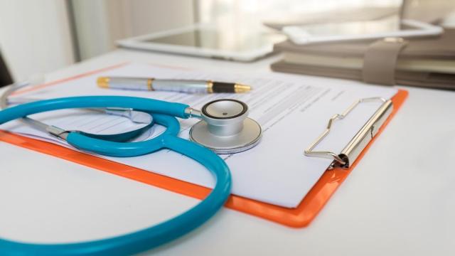 Un estetoscopio sobre un portadocumentos en una consulta.