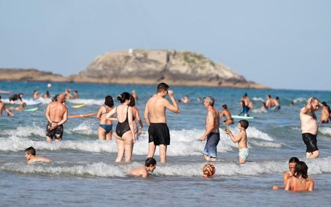 Personas bañándose en la playa de Zarautz este verano.