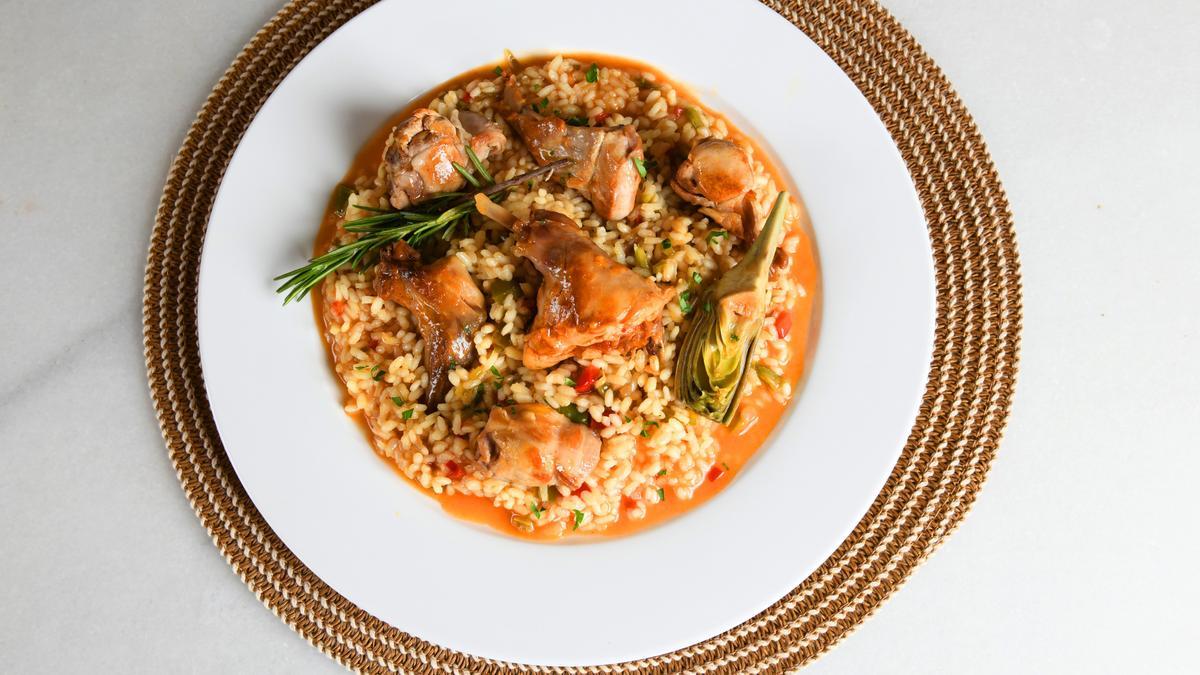 Un plato de arroz caldoso con conejo.