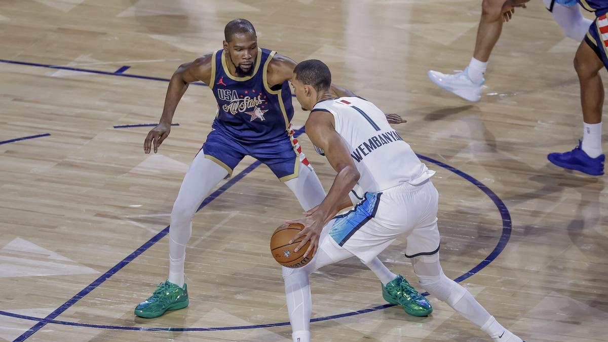 Victor Wembanyama, con el balón, frente a Kevin Durant.