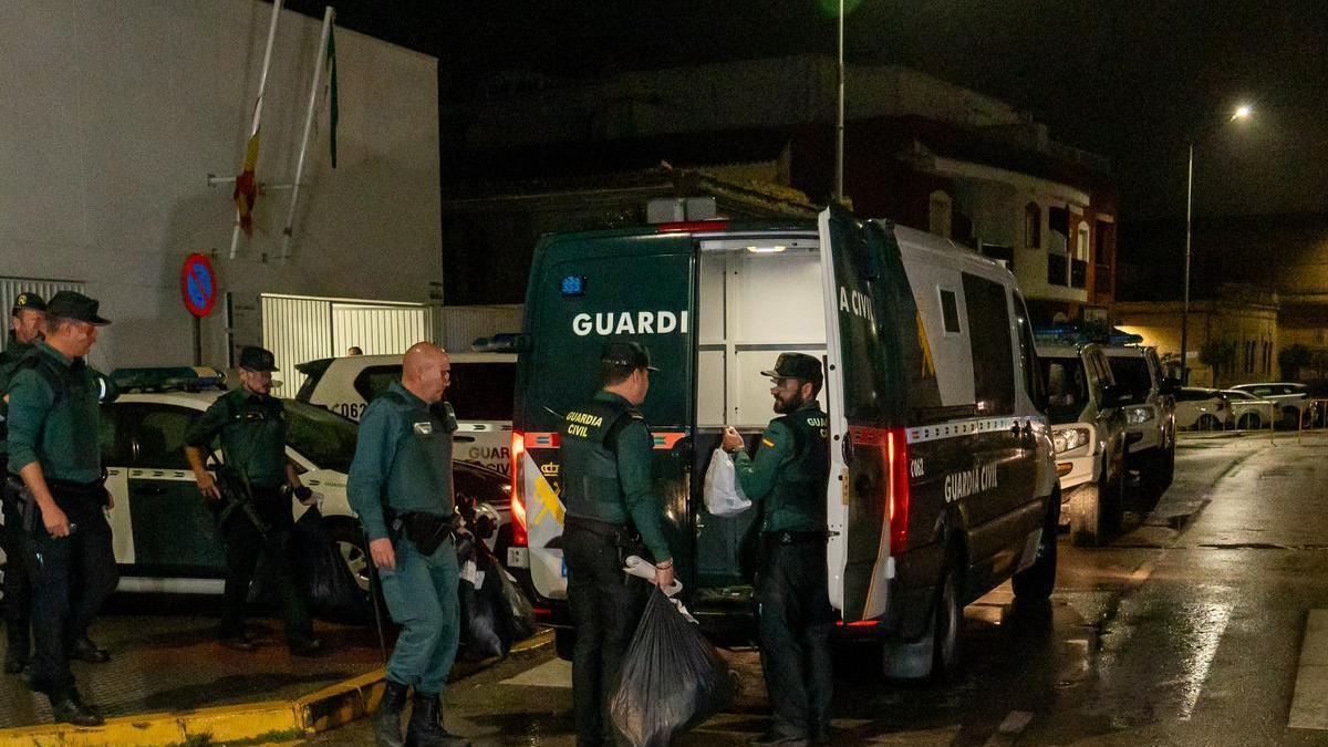 La Guardia Civil introduce en los furgones las pertenencias de los detenidos en Barbate.
