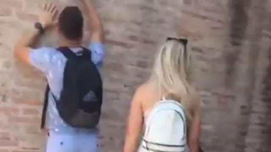 El joven escribiendo su nombre y el de su novia en el Coliseo.