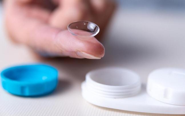 Lente de contacto junto a un estuche portalentillas.