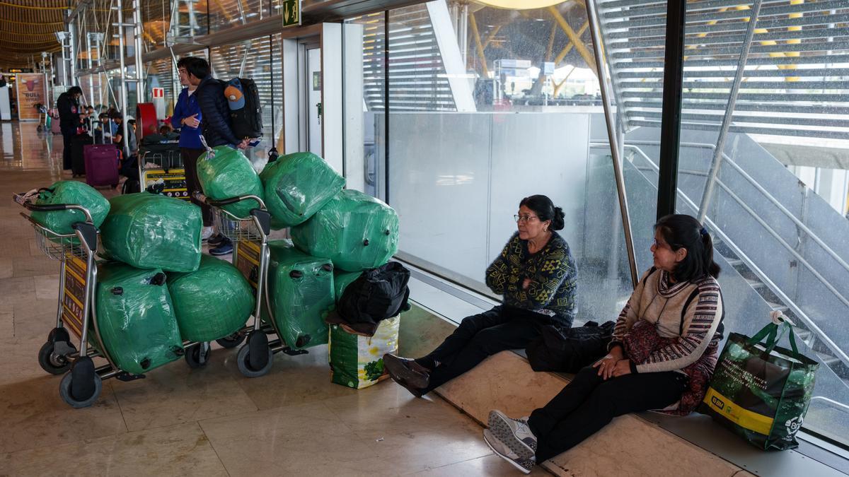 Varias personas sentadas en la terminal T4 del aeropuerto Adolfo Suárez-Madrid Barajas