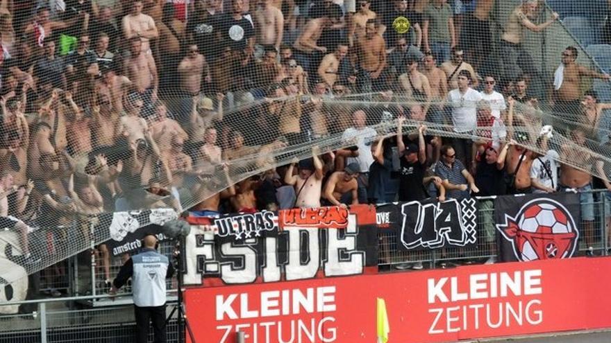 Ultras del Ajax levantan una red de seguridad durante un partido europeo en Austria, contra el Sturm Graz. / PICASA