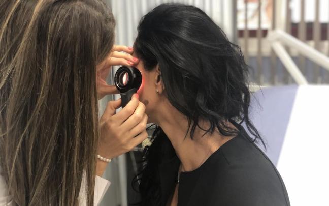 Una sanitaria examina unas manchas solares en la cara para ver si son o no malignas