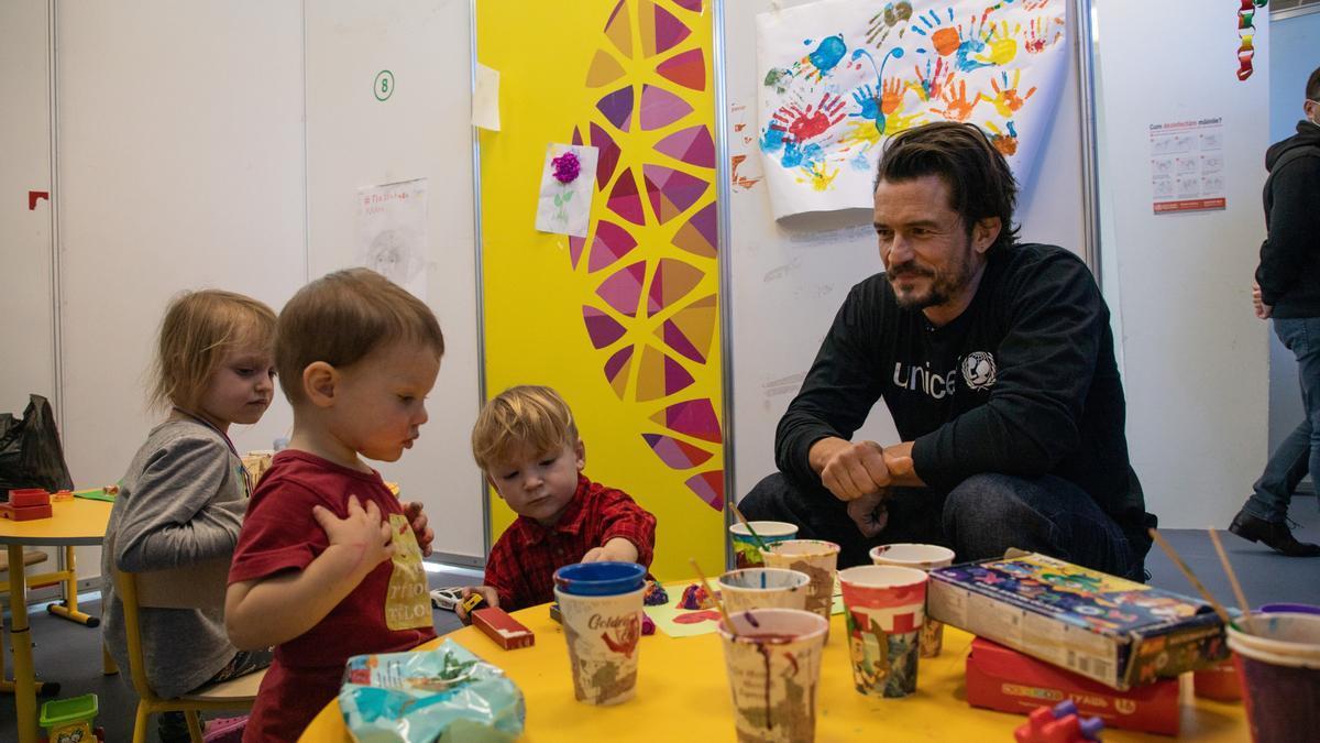 Orlando Bloom juega con niños refugiados que huyen de la guerra en Ucrania, en el centro Moldexpo, en Moldavia.