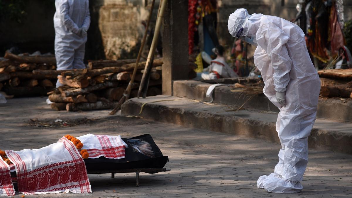 Un familiar de una víctima de covid en la India, antes de una cremación.