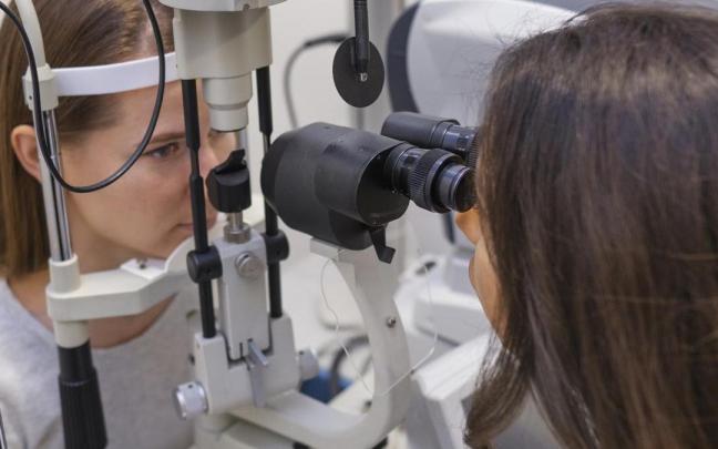 Una sanitaria revista la vista de una paciente.