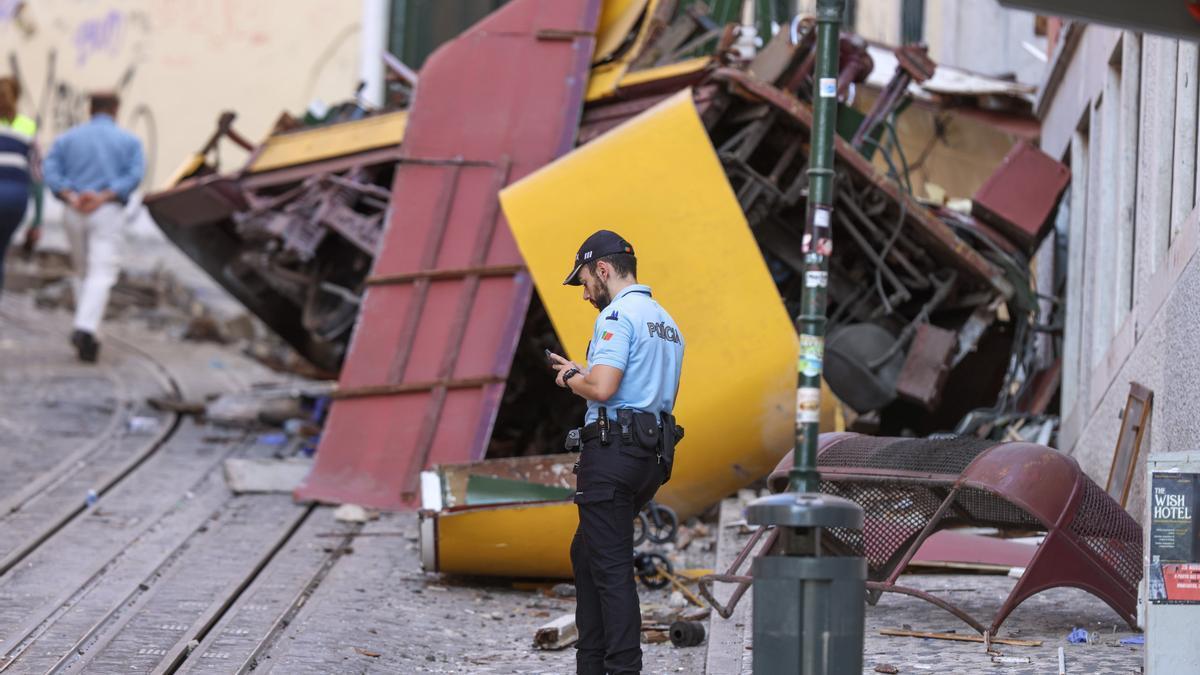 Un policía junto a los restos del Elevador de Gloria descarrilado en Lisboa