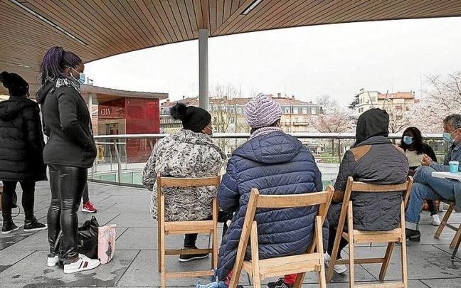 Un grupo de migrantes en tránsito junto a voluntarios de Irungo Harrera Sarea, en San Juan. | FOTO: IKER AZURMENDI