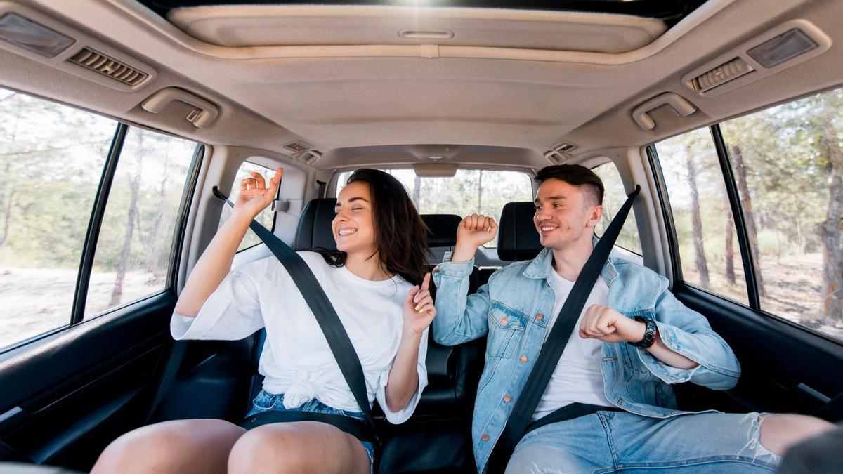 Una pareja, en losasientos posteriores de un coche.
