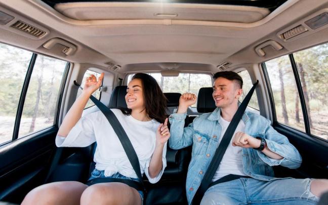 Una pareja, en losasientos posteriores de un coche.