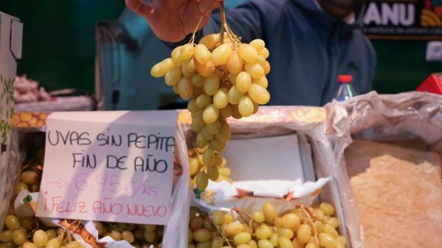 Expositor con uvas en una frutería de un mercado de abastos.