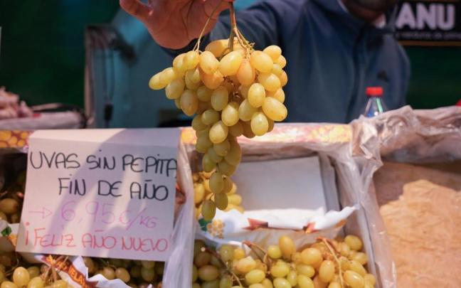 Expositor con uvas en una frutería de un mercado de abastos.