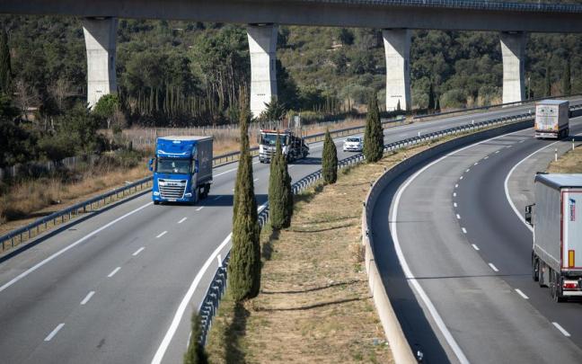 Varios camiones circulan por una carretera.