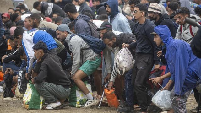 Numerosos migrantes durante el proceso de desalojo del embolsamiento de migrantes en la playa de El Trampolín.