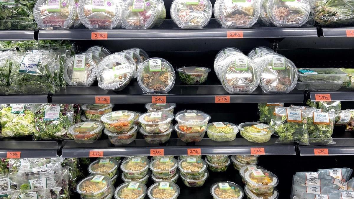 Neveras con packs de ensaladas en la sección de frutas y verduras de un supermercado.