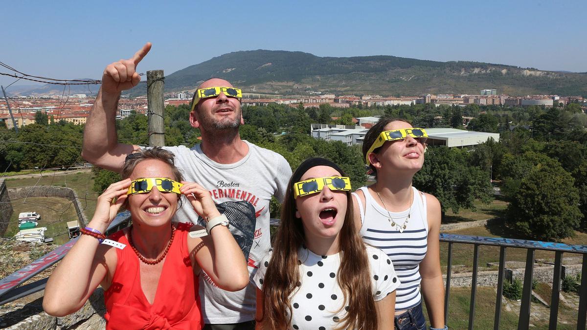 Una familia mira al cielo con las gafas protectoras.