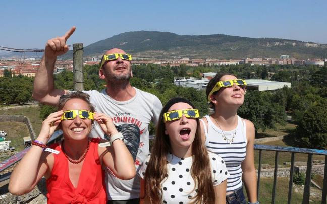 Una familia mira al cielo con las gafas protectoras.