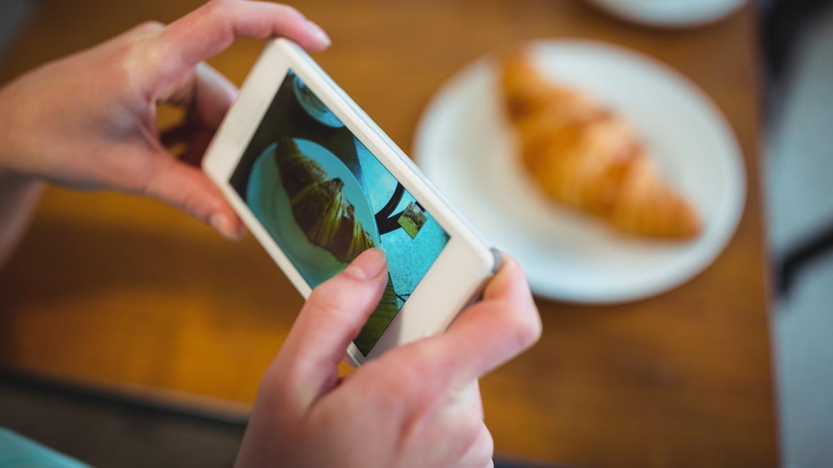 Fotografíando un cruasán para mostrárselo a su interlocutor.