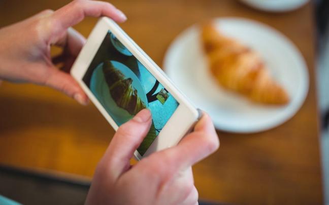 Fotografíando un cruasán para mostrárselo a su interlocutor.