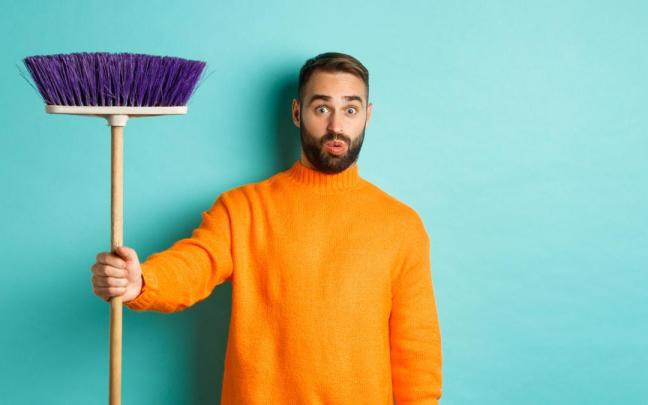 Hombre con una escoba en la mano.