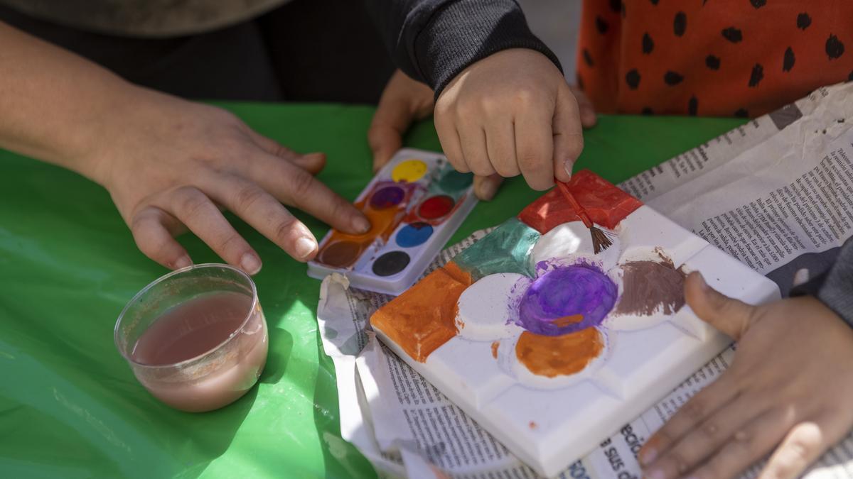 Unos niños se divierten jugando con unas pinturas al agua.