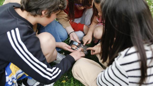 Varios niños mirando un móvil.