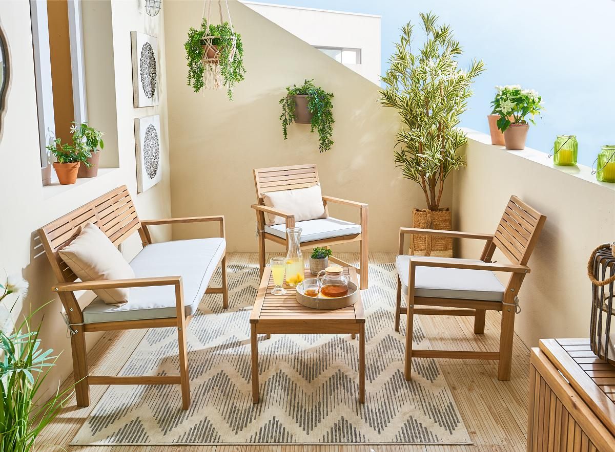 Terraza con mobiliario de exterior y muchas plantas.