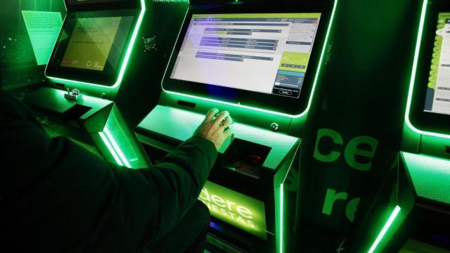 Un hombre haciendo apuestas deportivas en una sala de juegos.