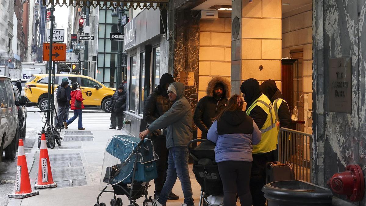 Un grupo de personas a las puertas de un refugio de migrantes en Nueva York.