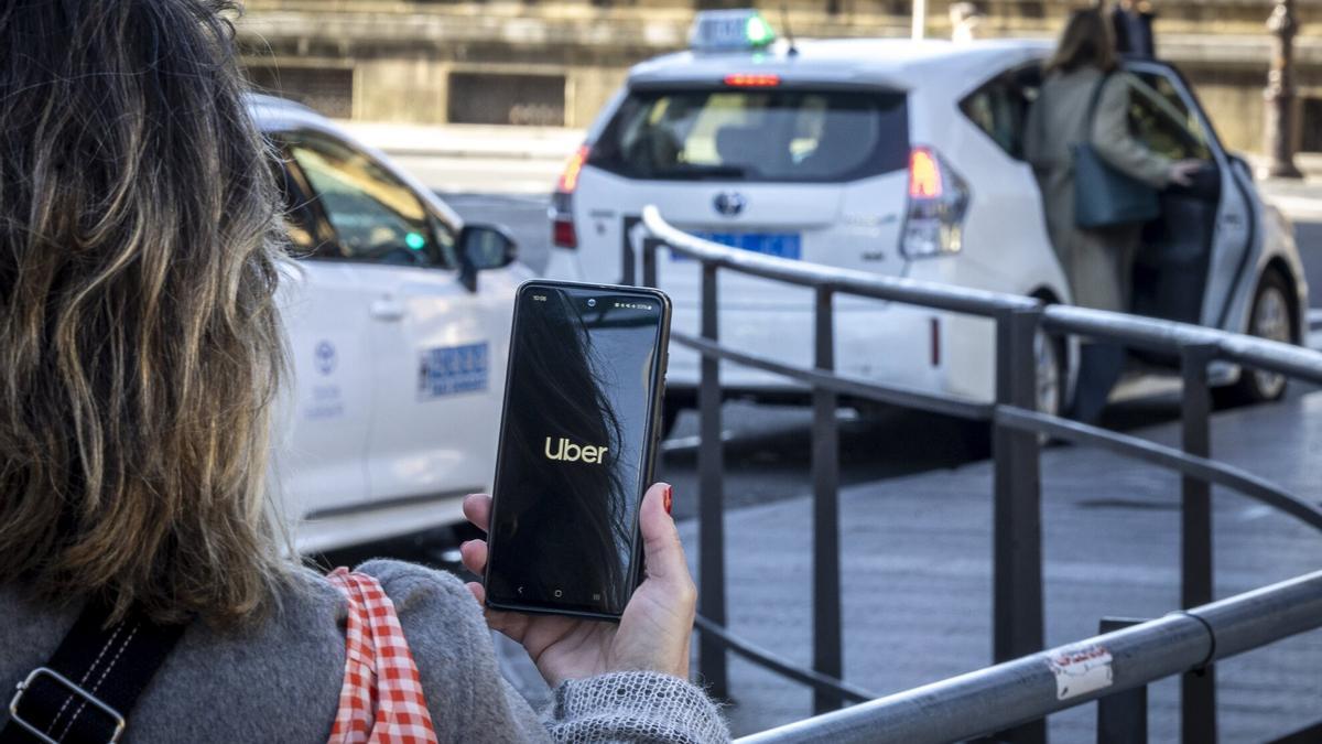 Una persona utiliza la aplicación de Uber en Donostia / Javier Etxezarreta