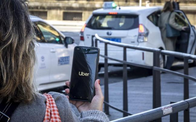 Una persona utiliza la aplicación de Uber en Donostia / Javier Etxezarreta