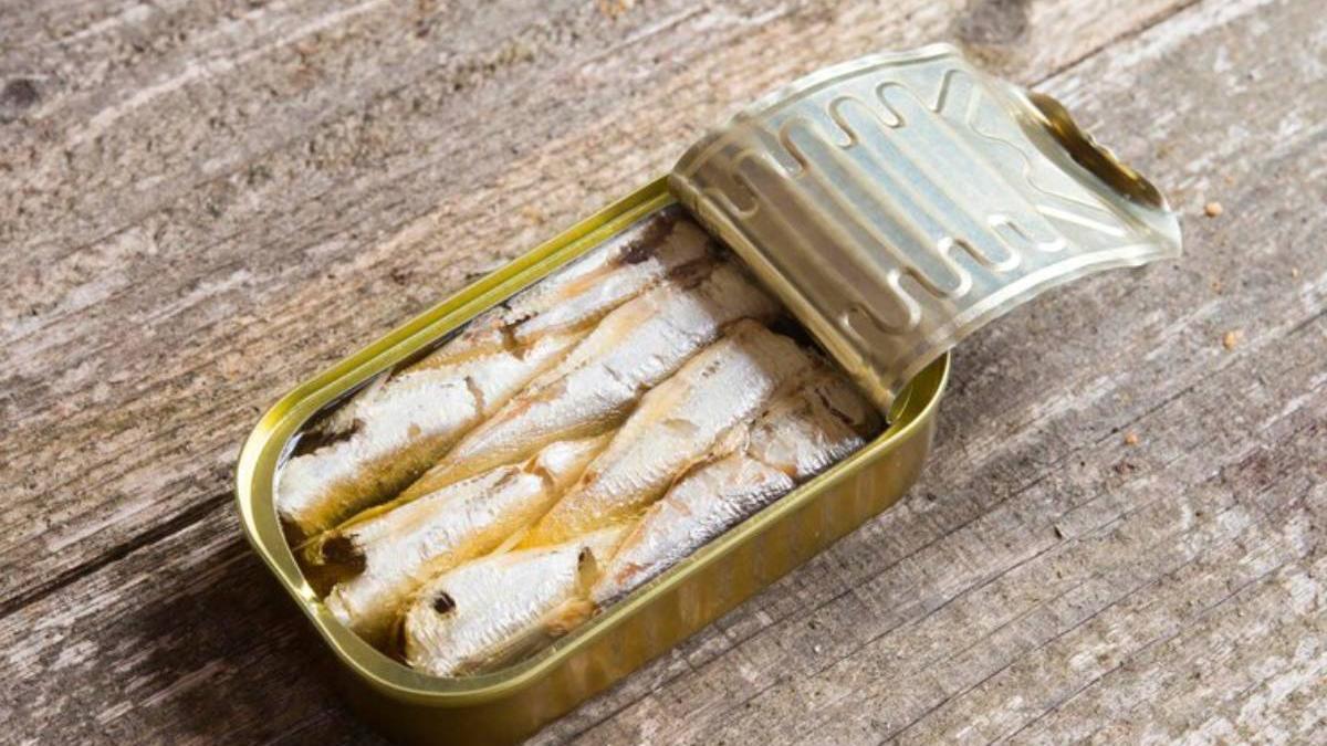 Sardinas en lata sobre una mesa de madera.