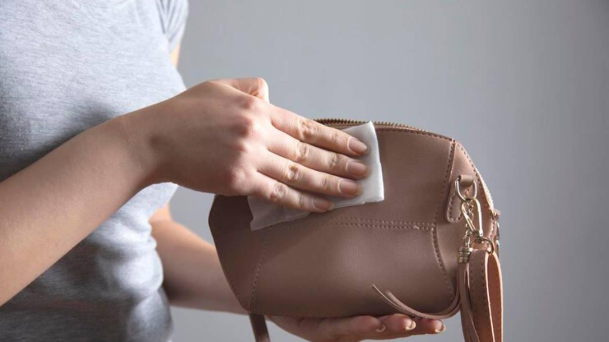 Primer plano de las manos de una chica limpiando su bolso.
