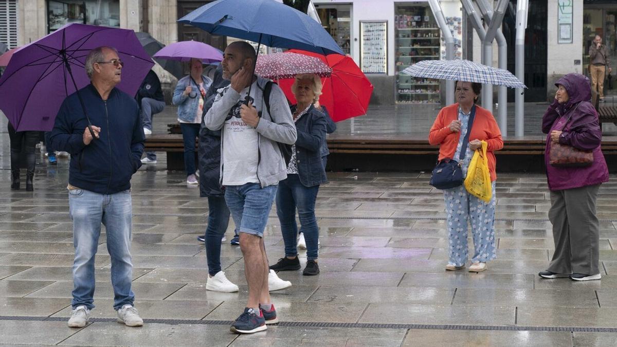 Un grupo de personas con paraguas bajo la lluvia.