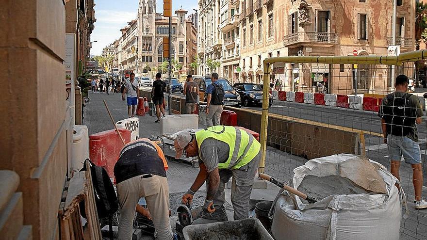 Dos trabajadores en plena tarea en una calle de Barcelona.