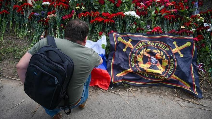 Un hombre deja flores para conmemorar la muerte de Yevgueni Prigozhin.