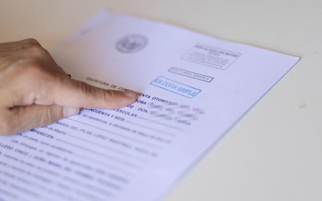 Una persona lee la escritura de compraventa de una hipoteca. / EP Una persona lee la escritura de compraventa de una hipoteca.