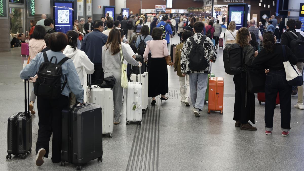 Decenas de pasajeros esperaban ayer en la estación de Atocha noticias sobre la reprogramación de sus viajes.