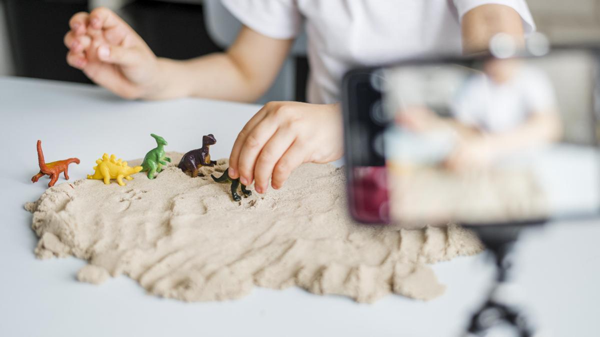 Niño jugando con arena artificial.