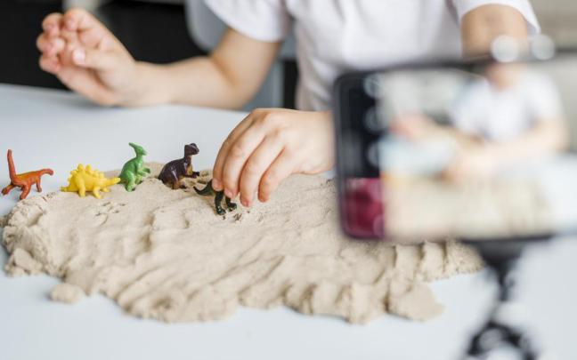 Niño jugando con arena artificial.