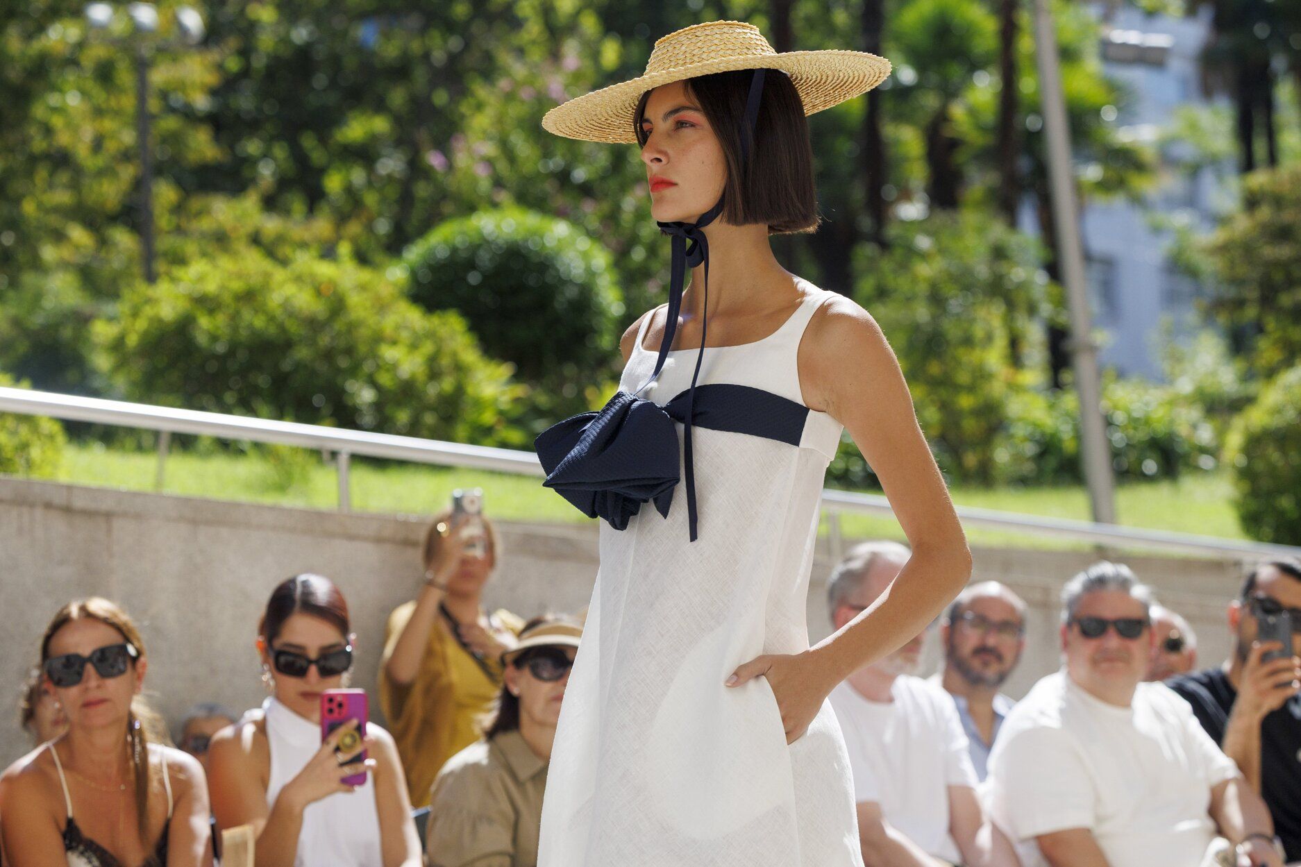 Una gran lazada en color negro contrasta y le da un aire coqueto a este vestido blanco.