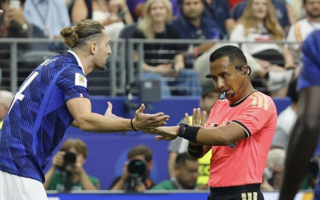 El salvadoreño Iván Barton, árbitro de la semifinal entre España y Francia, dialoga con Adrien Rabiot.